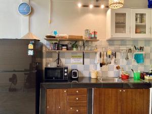 uma cozinha com um lavatório e um micro-ondas em Simple House Ao Nang - B&B em Krabi