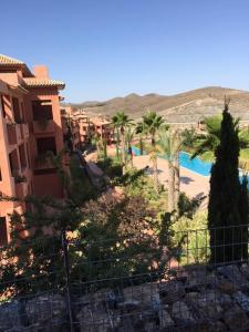 - Vistas a un complejo con palmeras y piscina en Appartement direct on the golf course and swimmingpool, en Purias