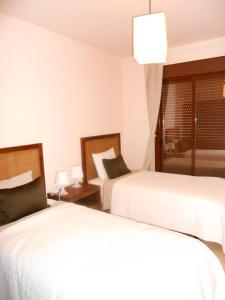 Habitación de hotel con 2 camas y ventana en Appartement direct on the golf course and swimmingpool, en Purias