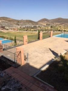 un patio con una valla junto a una piscina en Appartement direct on the golf course and swimmingpool, en Purias