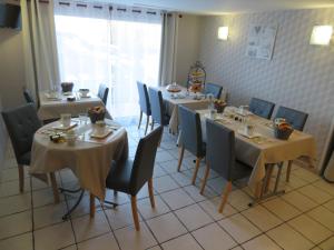 a dining room with tables and chairs and a window at Chambres d'Hotes La Maison Neuve in Saint-Loup