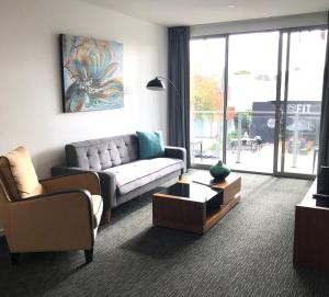 uma sala de estar com um sofá e uma mesa em The Palms Apartments em Adelaide