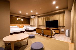 a hotel room with a living area with a television at Randor Residential Hotel Kyoto Suites in Kyoto