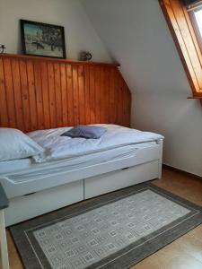 ein Schlafzimmer mit einem Bett mit einer Holzwand in der Unterkunft Haus mit Ausblick 3 Schlafzimmer in Wilkau-Haßlau