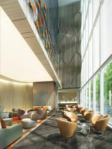 a lobby with couches and chairs in a building at The First Collection at Jumeirah Village Circle in Dubai