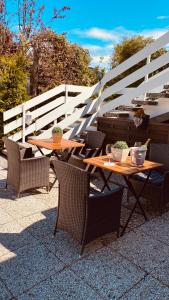 2 Tische und Stühle mit Pflanzen auf einer Terrasse in der Unterkunft Moin.Moin 2 in Grömitz