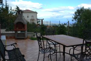 eine Terrasse mit einem Tisch, Stühlen und einem Kamin in der Unterkunft Agriturismo Dolcetna in SantʼAlfio