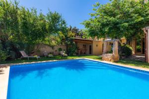 a large blue swimming pool in front of a house at Ca Ma Mare in Sant Llorenç des Cardassar