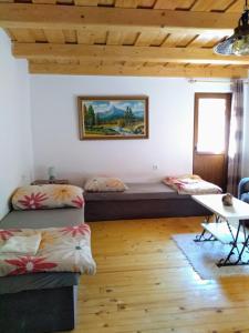 Cette chambre comprend 2 lits et une table. dans l'établissement Vilka Tkáč, à Kvačany