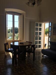d'une salle à manger avec une table, des chaises et une fenêtre. dans l'établissement Masseria Piccola Convertino by Apulia Hospitality, à Faccia di Trippa