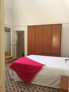 - une chambre avec un grand lit et une couverture rouge dans l'établissement Masseria Piccola Convertino by Apulia Hospitality, à Faccia di Trippa