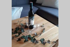 a bottle of wine and a glass on a table at Haus Fritz - Erholung in den Bergen in Donnersbachwald