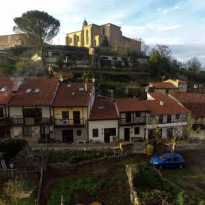 a group of houses on a hill with a yellow building at Falagueira in Monforte de Lemos