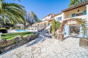 a house with a stone walkway leading to a swimming pool at B&B Villa Ganesh in Le Rouret