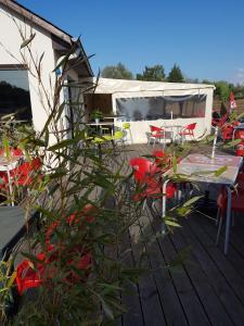 une terrasse avec des chaises et des tables ainsi qu'une tente dans l'établissement Aux Cygnes D'Opale, à Blangy-sur-Bresle