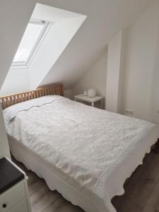 a bedroom with a white bed and a window at Gallery Balta Apartments in Kaunas