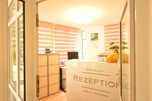 una oficina con mostrador de recepción y escritorio en Hotel Weinert, en Neubrandenburg
