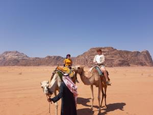 two people riding on camels in the desert at Wadi Rum Desert Secret in Wadi Rum