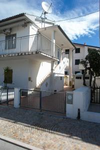 Casa blanca con escalera y valla en M116 - Marcelli, bilocale in centro e fronte mare, en Marcelli