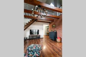 an open living room with wooden floors and a staircase at Willa Spokojne Wzgórze in Pławna