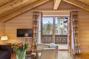 a living room with a couch and a large window at Grand Hotel Zermatterhof in Zermatt