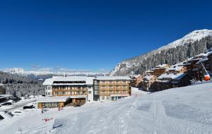 ゾンネンアルペ・ナスフェルトにあるAlmhotel Kärntenの雪面スキー場スキーロッジ