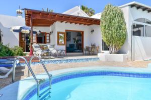 a villa with a swimming pool and a house at Villa Alex in Puerto del Carmen