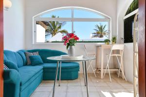 a living room with a blue couch and a table at Villa Alex in Puerto del Carmen
