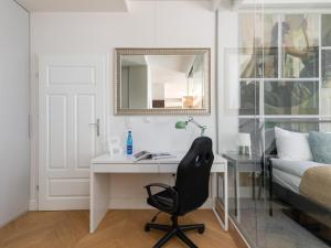 Schlafzimmer mit einem Schreibtisch, einem Bett und einem Spiegel in der Unterkunft Rent like home - Ogrodowa 65 in Warschau