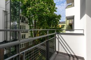 einen Balkon mit einem Baum in der Mitte eines Gebäudes in der Unterkunft Rent like home - Ogrodowa 65 in Warschau