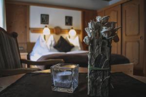 wazon kwiatów na stole ze świecą w obiekcie Landhaus Andrea Saalbach w Saalbach Hinterglemm