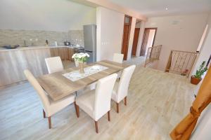 a dining room with a wooden table and white chairs at Villa Sofia in Kotor