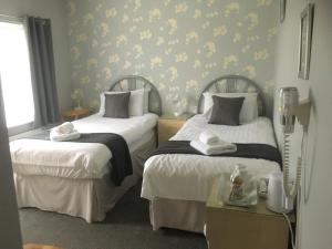 a bedroom with two beds with towels on them at The Ramblers in Trusthorpe