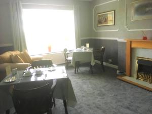 a living room with two tables and a fireplace at The Ramblers in Trusthorpe