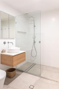 een badkamer met een douche en een wastafel bij Pura Vida in Noosa Heads