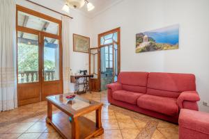 a living room with a red couch and a table at Ses Comes de Son Cladera in Manacor