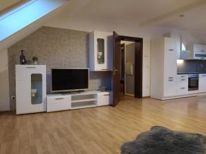 a living room with a flat screen tv and white cabinets at City FeWo in Schwelm