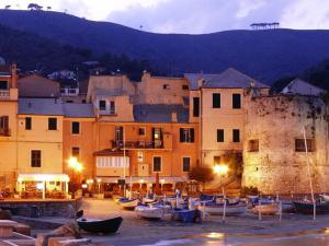 a group of boats sitting on the sand in front of buildings at Appartamento Via Dei Glicini in Laigueglia