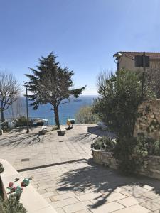 een patio met een boom en uitzicht op de oceaan bij Ca' del Vescovo in Costarainera