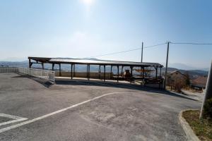 a bus stop with a roof on the side of a road at Al Hayat Apartments in Vogošća