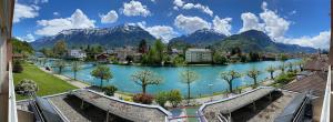 - une vue sur une rivière avec des montagnes en arrière-plan dans l'établissement Aparthotel Goldey, à Interlaken