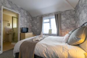 a bedroom with a bed with a cat sitting on it at The Ramblers in Trusthorpe