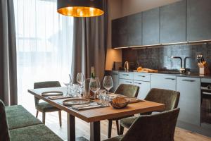 Mountainview Apartments في وستندورف: مطبخ مع طاولة خشبية مع كؤوس للنبيذ