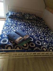 a bed with a blue and white comforter on it at Niezapominajka Kopalino in Kopalino