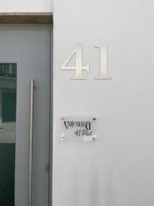 eine weiße Tür mit einem Schild, auf dem steht: in der Unterkunft ValentinaPlace in Alcácer do Sal