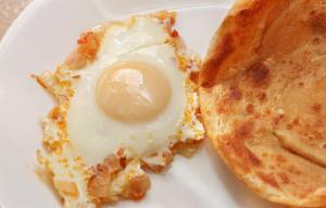 a fried egg on a white plate with a sandwich at The City Lodge in Islamabad