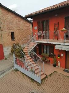 ein rotes Backsteingebäude mit einer Treppe davor in der Unterkunft Casa Carolina in Castellinaldo