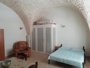 a bedroom with a bed and a chair and a table at Casa Vacanze Giovanni Cesare in Noci