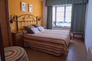ein Schlafzimmer mit einem großen Bett und einem Fenster in der Unterkunft Alojamientos Casa Luisa in Puertas