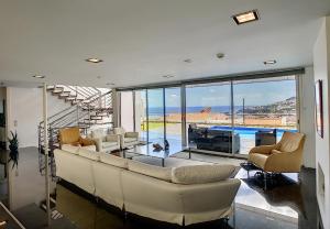 een woonkamer met een bank en stoelen en een zwembad bij The White House - By LovelyStay in Funchal